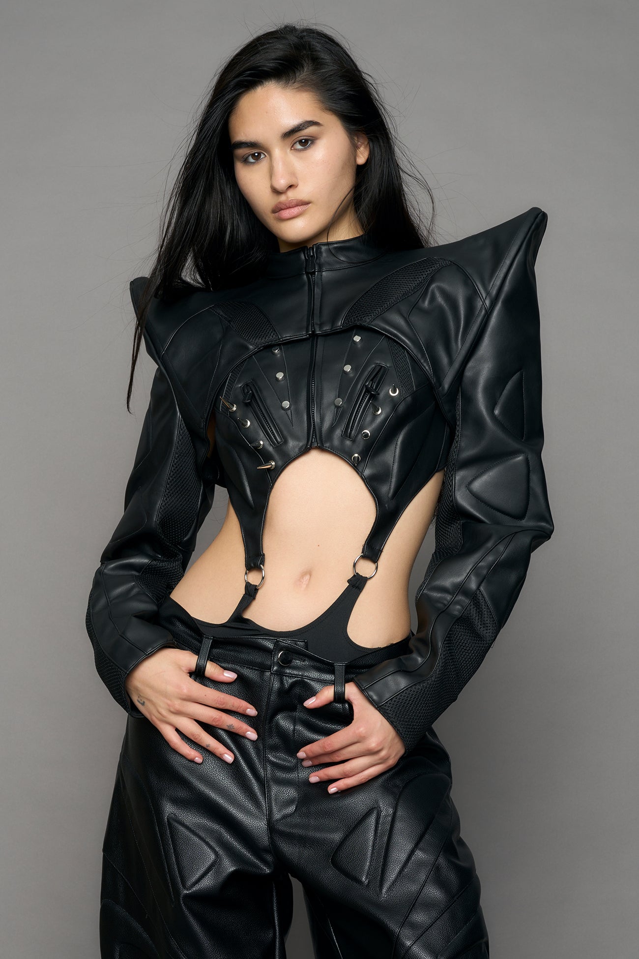 Model wearing a black leather choker jacket with cut-out design