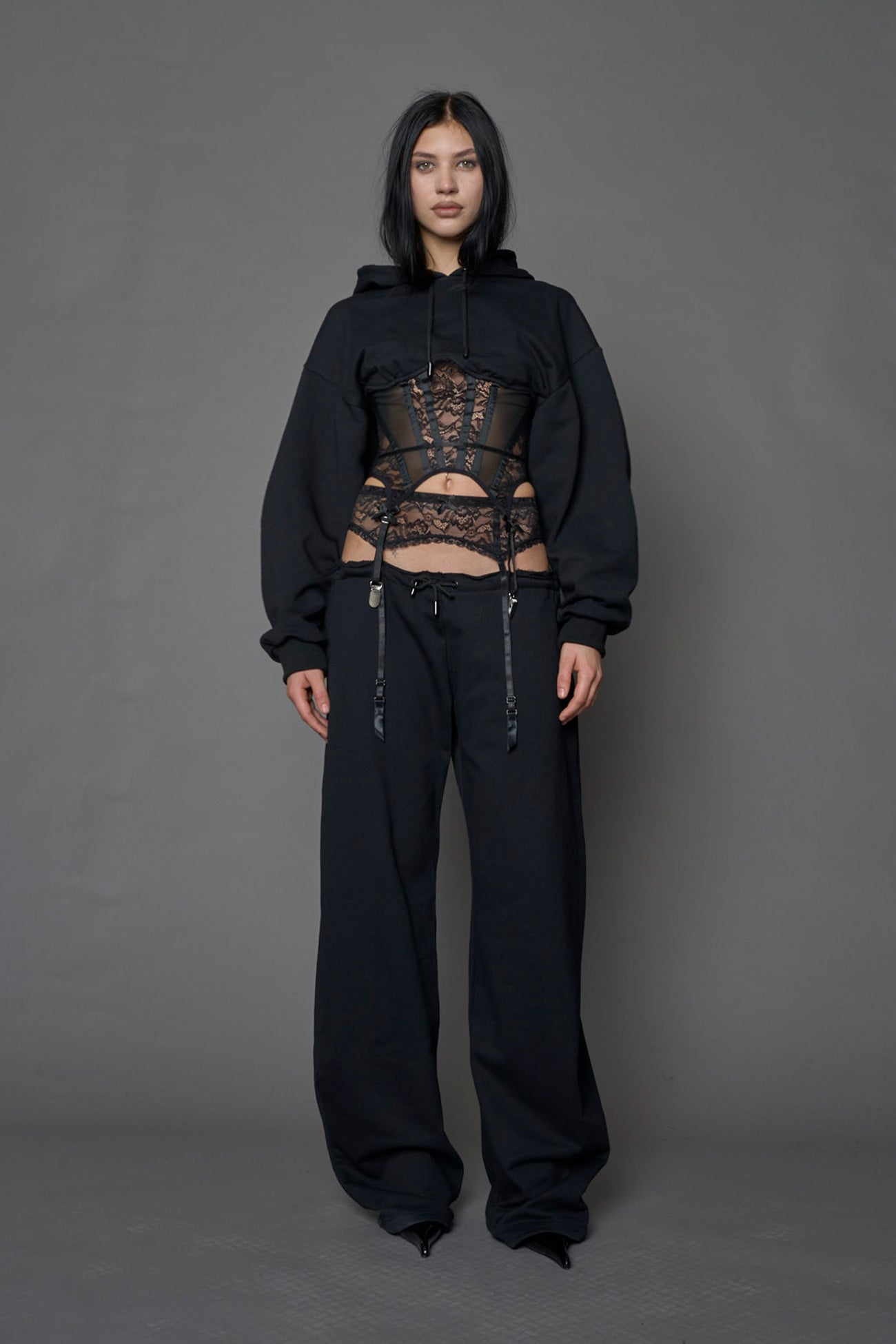 model wearing a lingerie-inspired black hoodie with a lace corset