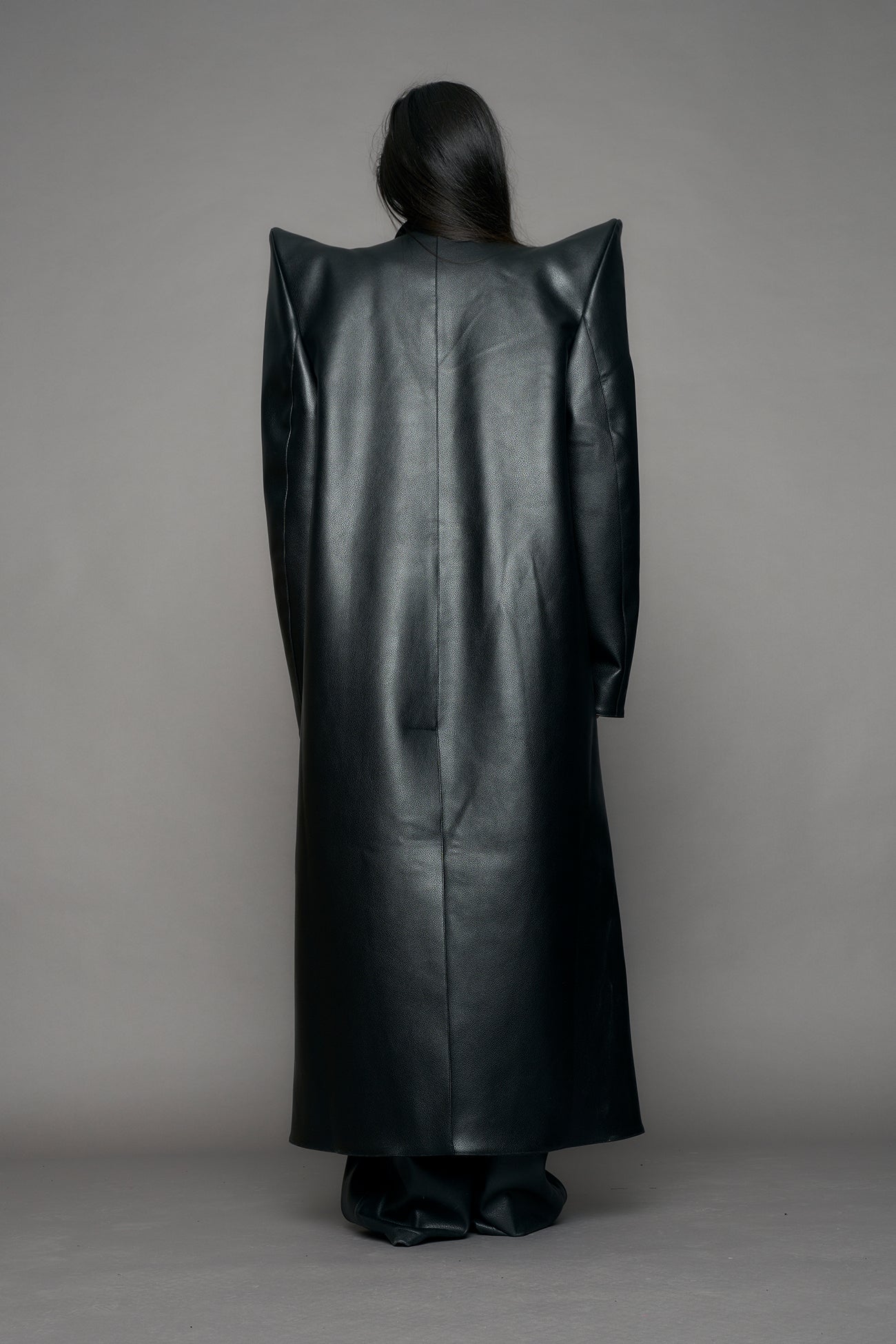 model wearing black pu leather coat with sharp shoulder design