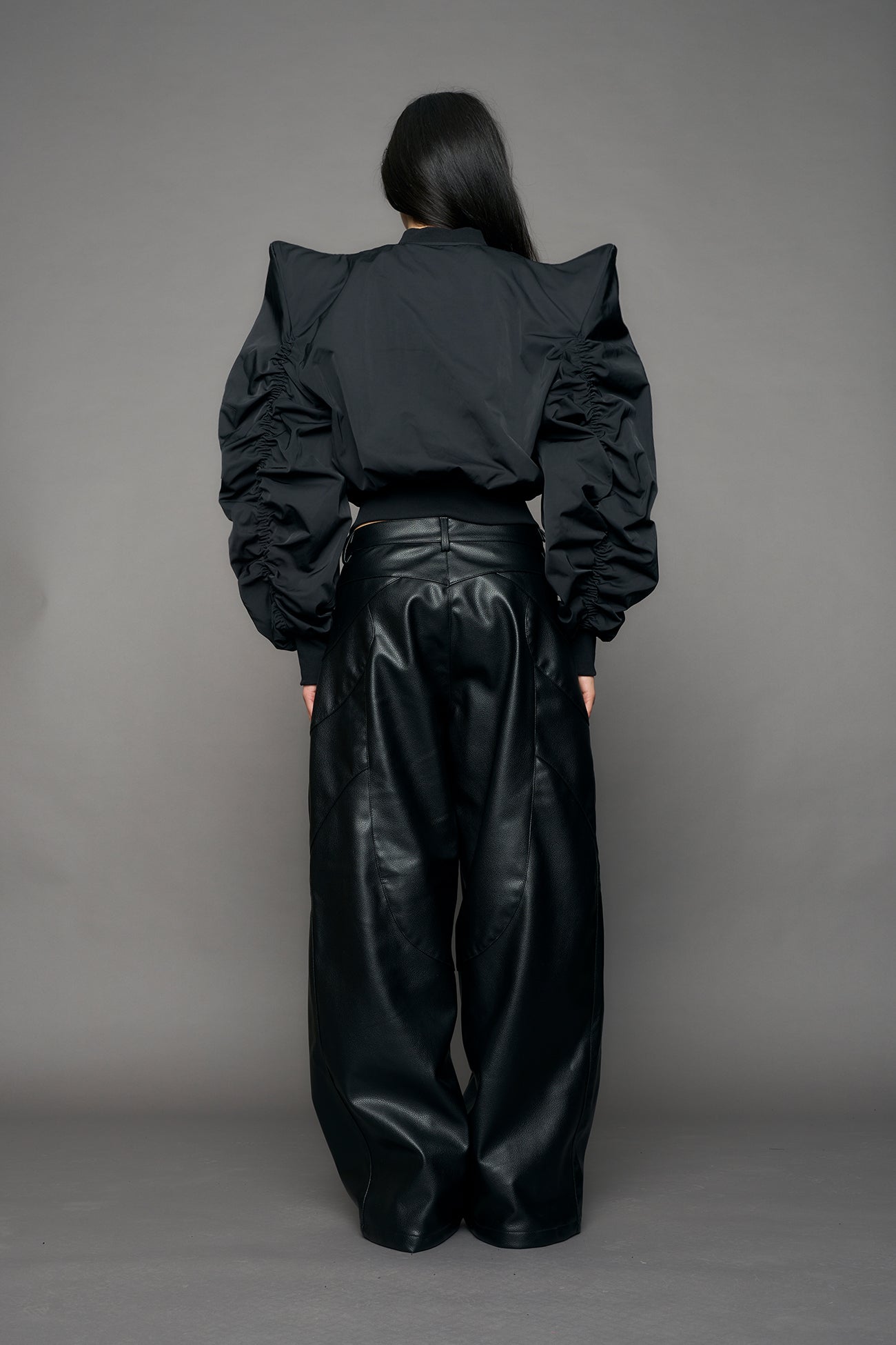 model wearing black bomber jacket with sharp shoulder design