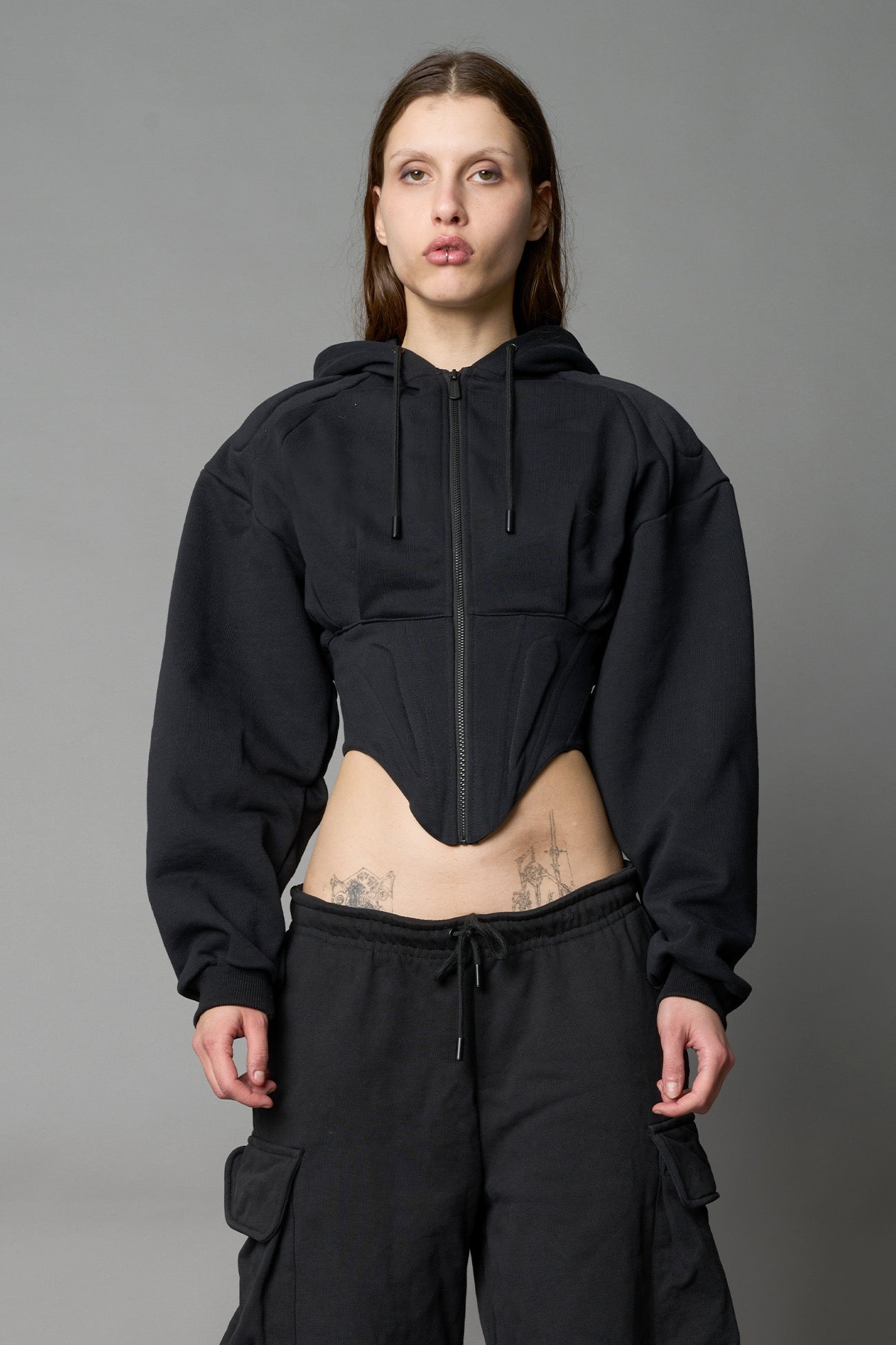 model wears black oversize hoodie with integrated corset