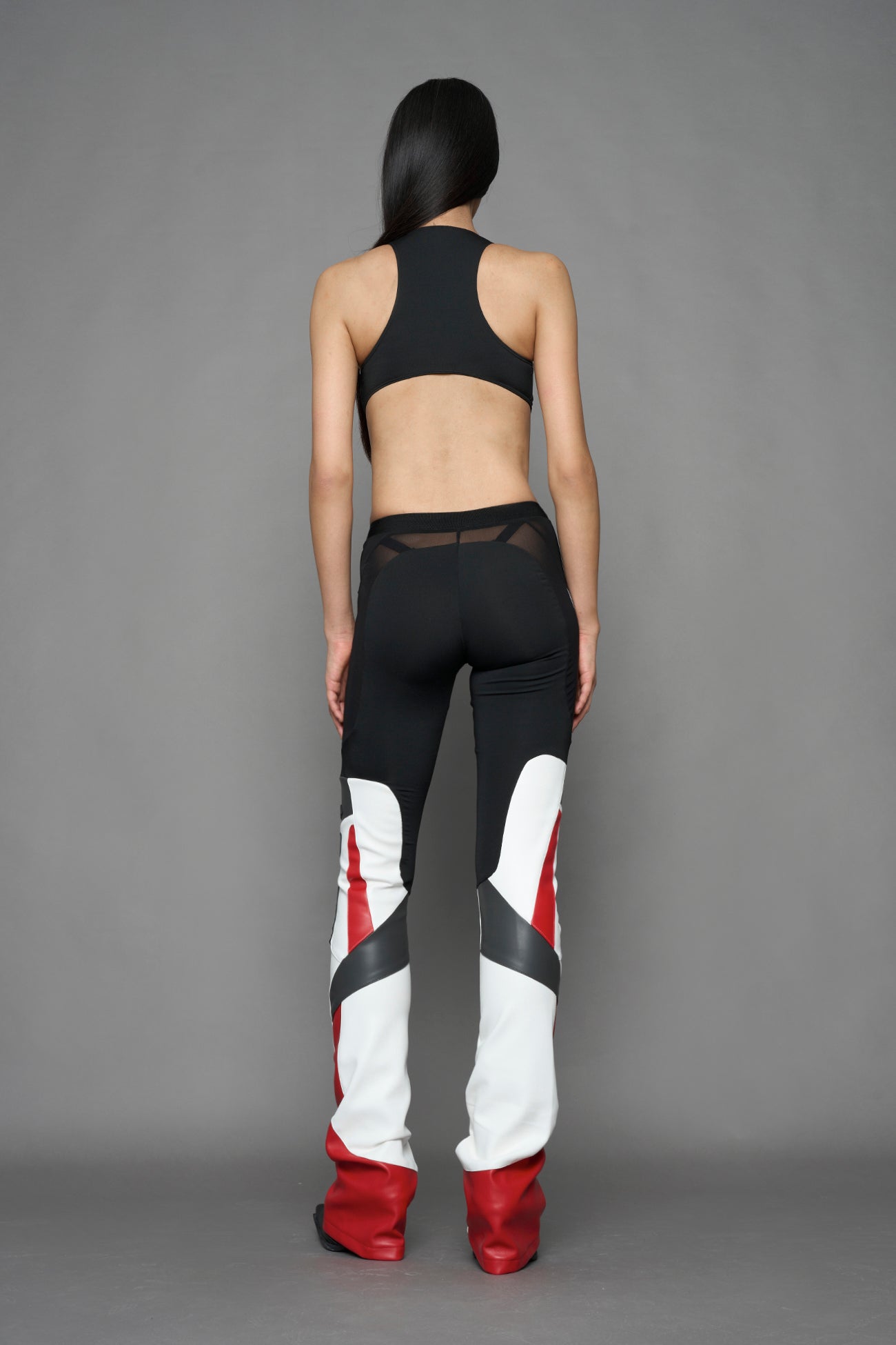 model wearing red black white moto inspired mesh pants with logo on the leg