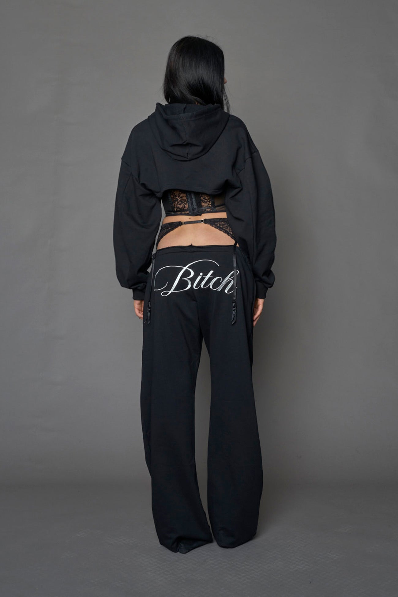 model wearing a lingerie-inspired black hoodie with a lace corset 