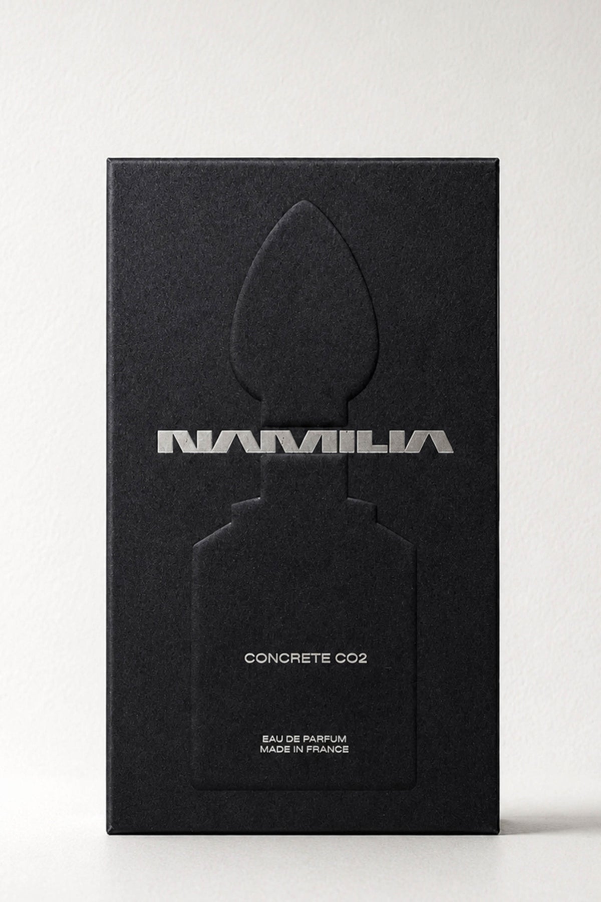 Namila perfume bottles with metallic silver shaped caps and clear glass bases, filled with pale yellow liquid