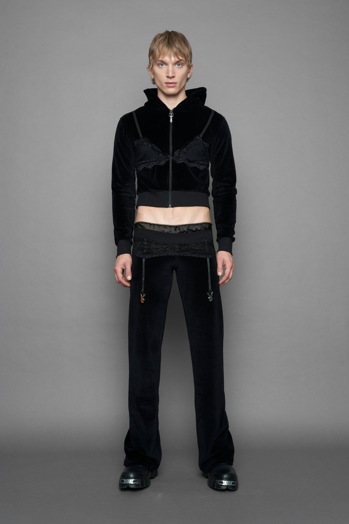 model is wearing a black velvet cropped zip-up hoodie with a black lace bralette and a Playboy branded key formed Zipper Pull 
