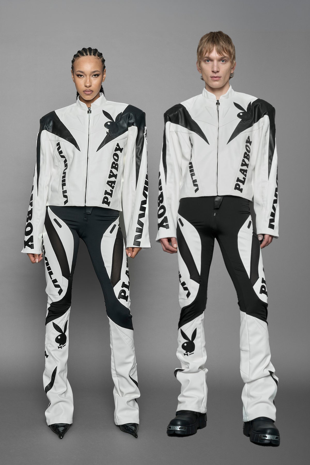 model wearing white vegan leather zip-up jacket with black PU leather 'Namilia' and 'Playboy' embroidery and black and white paneling. On the left chest there is a white Playboy Bunny Embroidery.