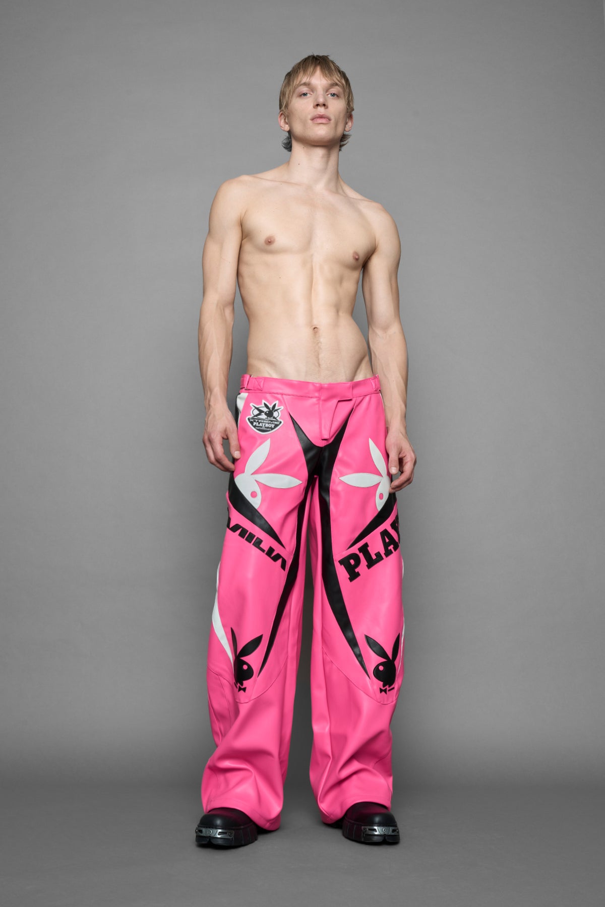 model is wearing pink PU Leather pants with bold white Playboy bunny logos and white 'Namilia' Embroidery and rubber tag.